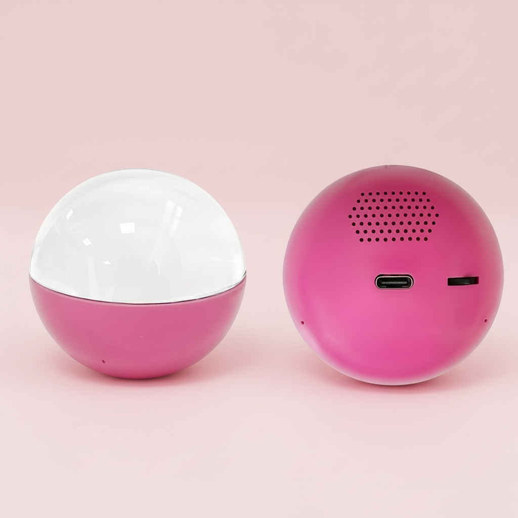 Two spherical devices, one pink and white, the other pink with a speaker grille, on a pink background.
