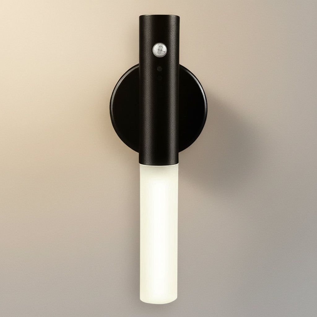 Black wall-mounted light fixture with a white bulb on a white background