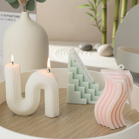 Decorative candles and a small sculpture on a wooden surface with a blurred background